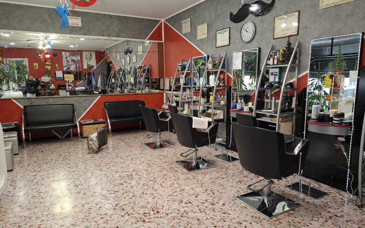 Fila di poltrone da barbiere con specchi e mensole